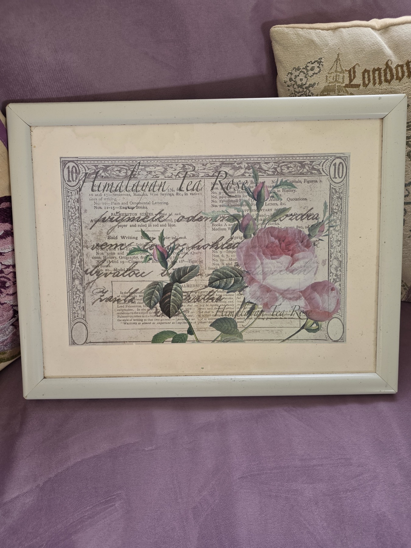 A cream-framed tray decorated with roses and printed script
