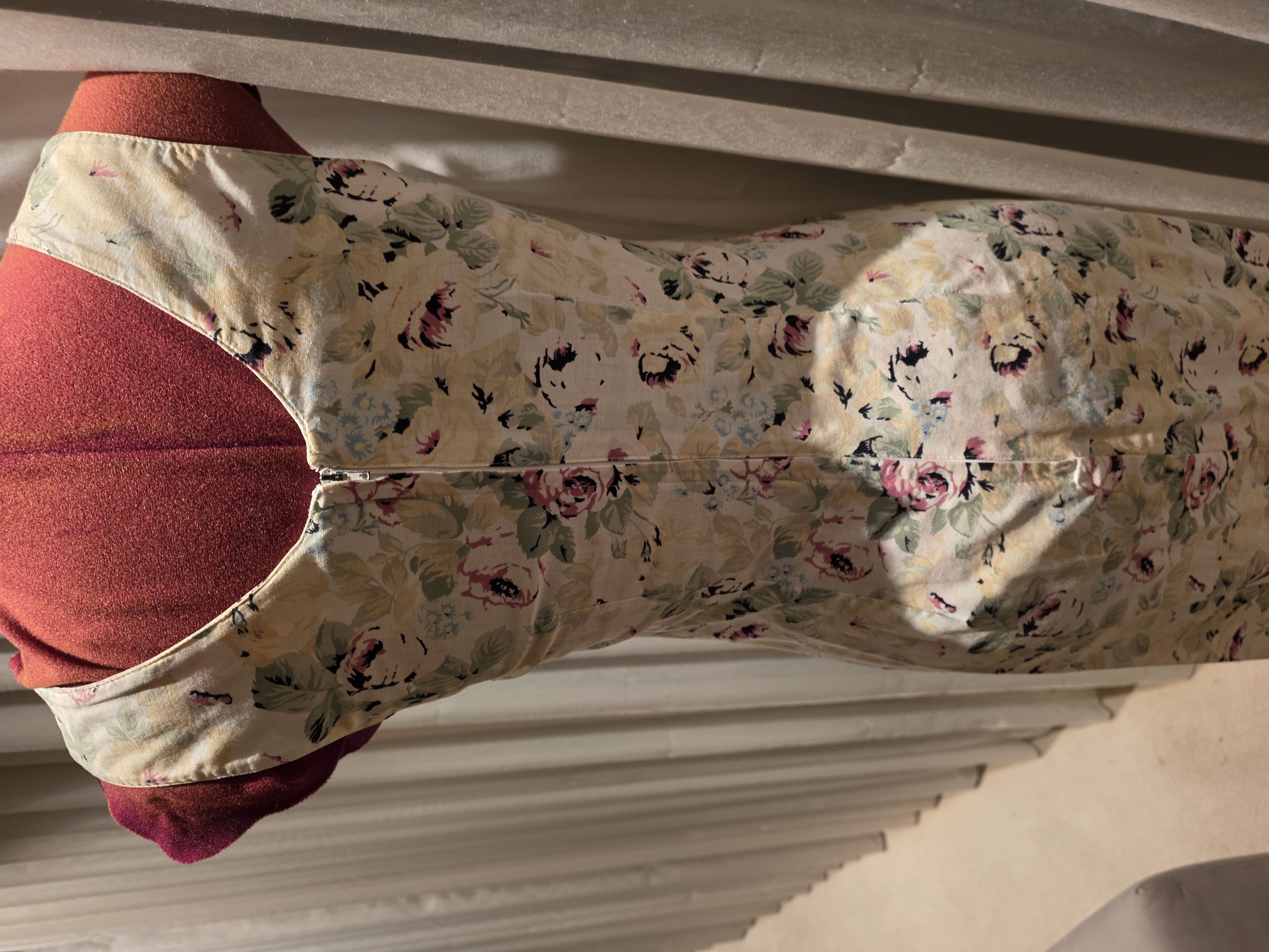 Back view of the cream floral dress showing its scooped neckline, fitted seams and centre zip