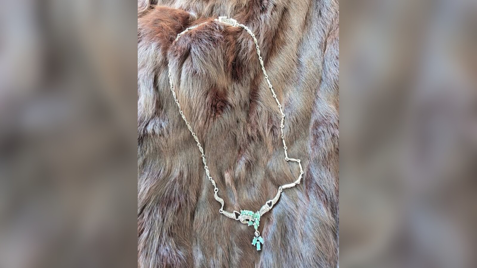 An Art Nouveau chrysoprase and marcasite necklace resting on a treasured fur stole
