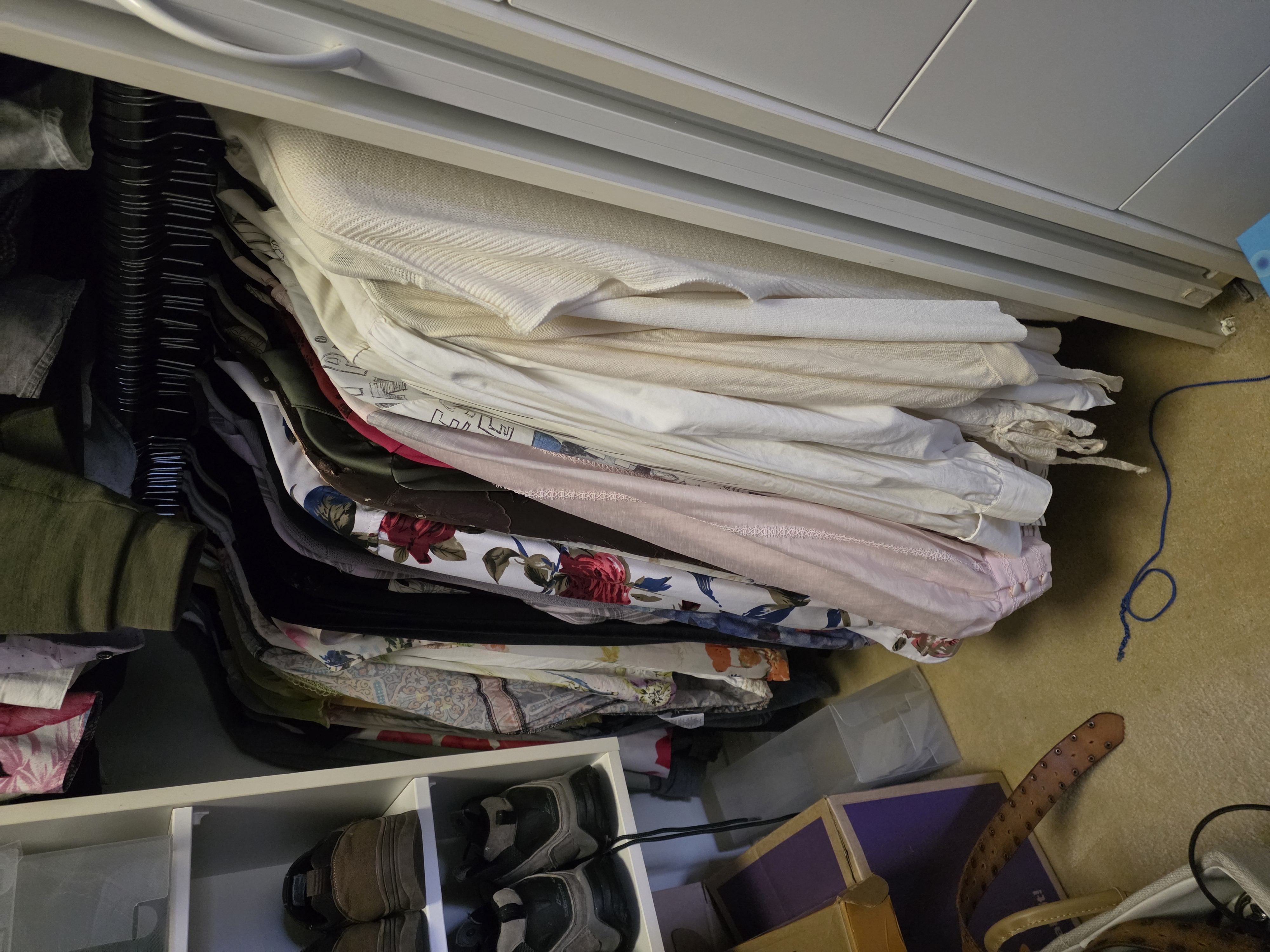 Shirts hanging together on a wardrobe rail in colour groups